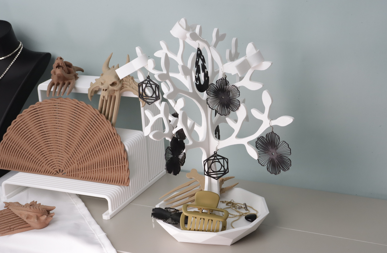 3D printed white jewelry tree organizer with earrings, hair clips, and accessories on a vanity table.